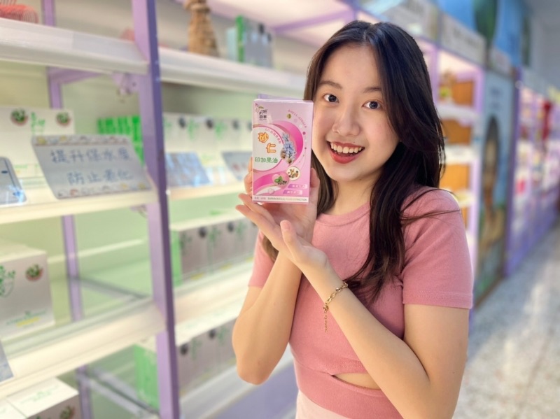 遊客在月桃故事館禮品店手持月桃商品微笑