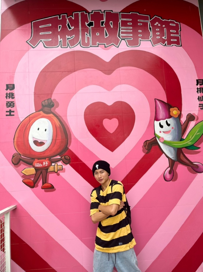 遊客站在月桃故事館粉紅愛心壁畫前拍照